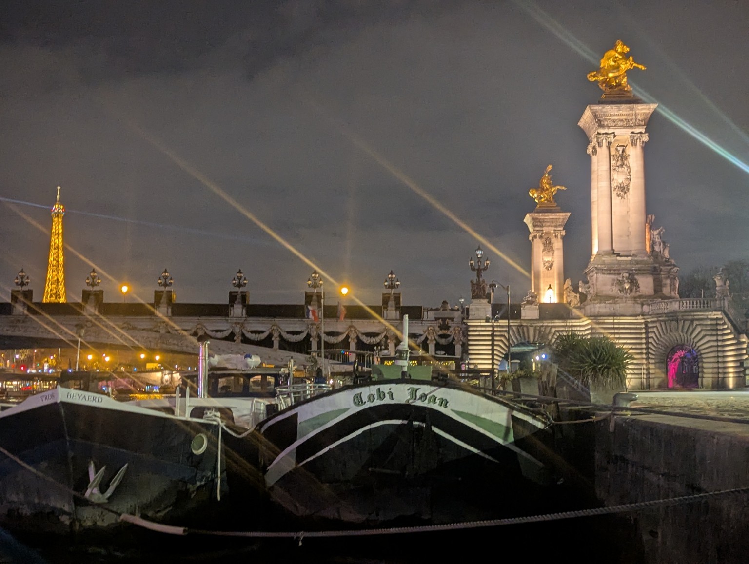 A Paris bridge illuminated at night